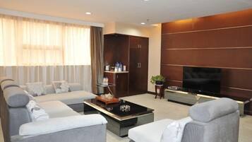 Una sala moderna con un conjunto de sofá, una mesa de centro, un televisor y estanterías empotradas.