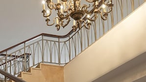 A staircase with a wrought iron railing and a chandelier. - Kuntai Novel Hotel Beijing (Beijing)