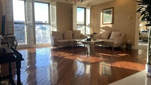 A spacious living room with a large window, a chandelier, and a piano. - Kuntai Novel Hotel Beijing (Beijing)