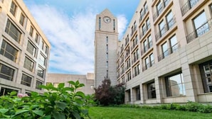 A courtyard with a clock tower, surrounded by modern buildings with balconies. - Kuntai Novel Hotel Beijing (Beijing)
