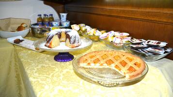 Una mesa de buffet con diversos postres, incluyendo tartas y pastelería.