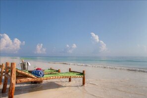 Plage, sable blanc, chaises longues, parasols