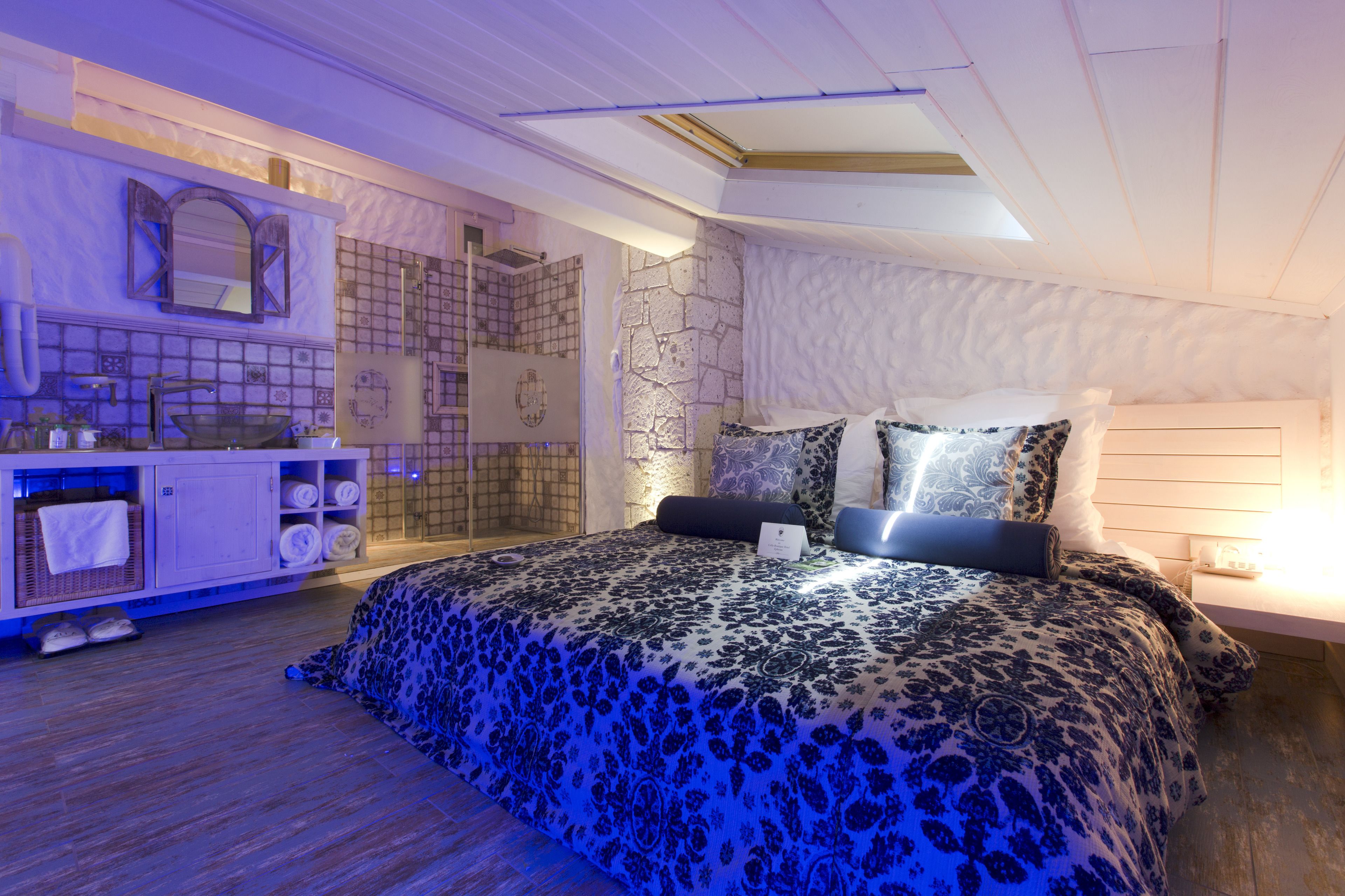 Un dormitorio con una cama grande, un tocador con espejo y una zona de ducha.
