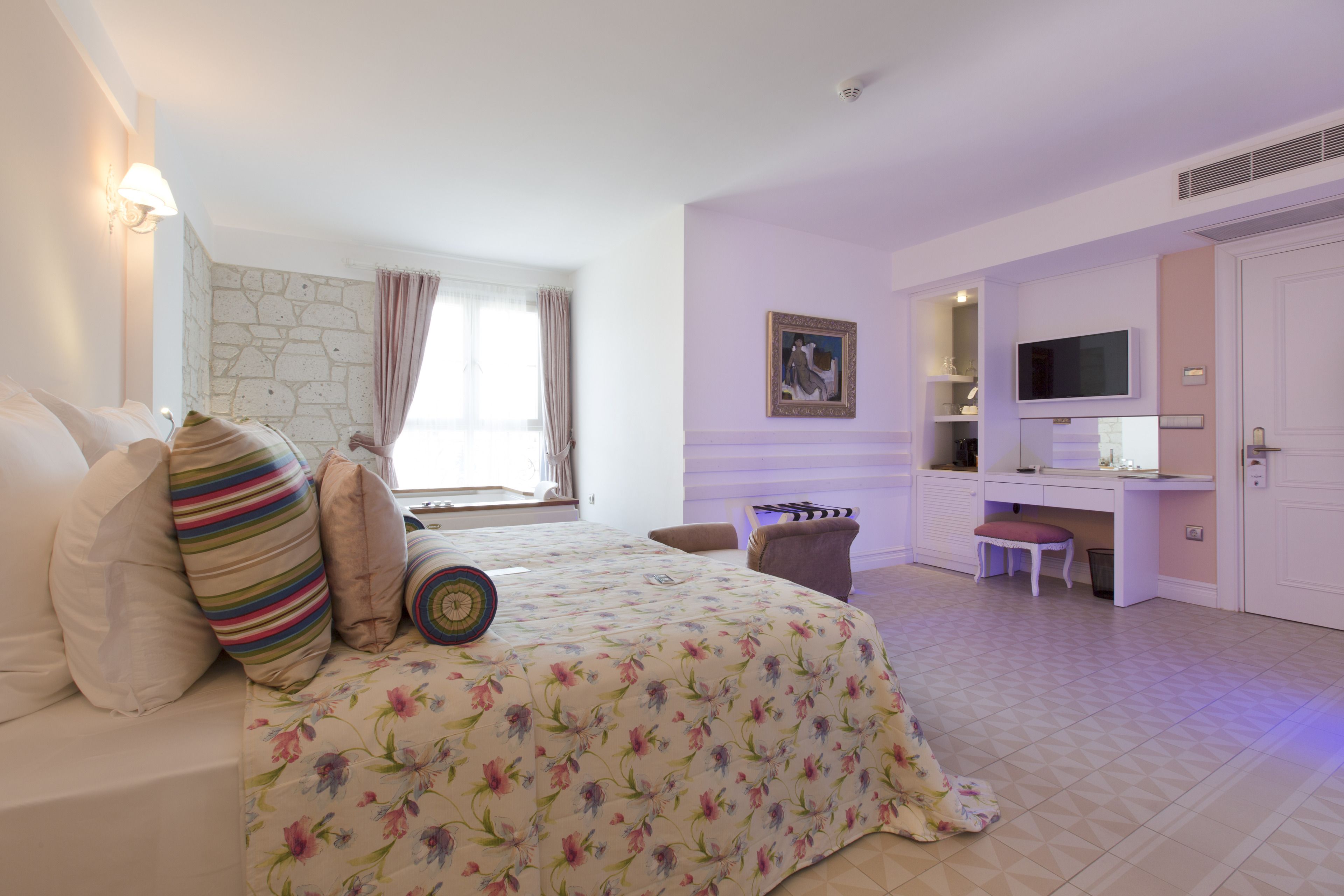Une chambre à coucher avec un lit, un bureau, une chaise et un téléviseur.