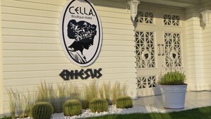 Señal de hotel con la silueta de una mujer y el nombre 'CELLA Boutique Hotel'.