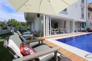 Piscine extérieure, parasols, chaises longues