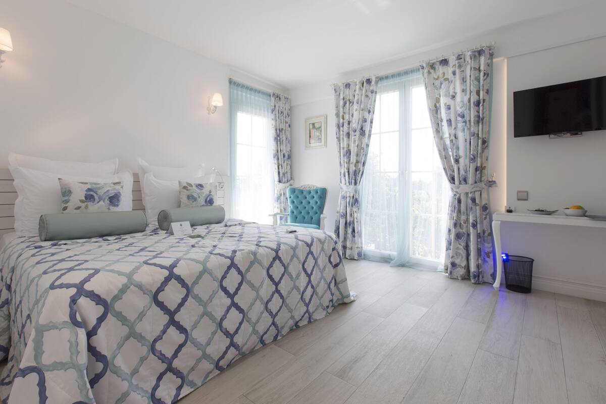 Un dormitorio con cama, una silla, un escritorio y televisor.