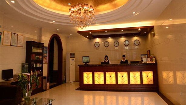 A hotel reception area with a chandelier, a reception desk, clocks, and a large arched doorway. - GreenTree Inn BengBu HuaiHe Road Pedestrian Street Hotel (Bengbu)