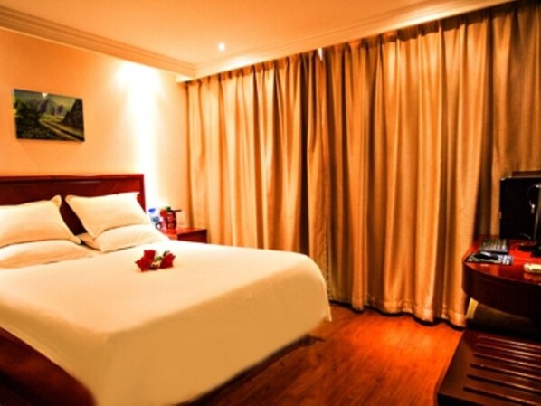A hotel room with a large bed, a wooden headboard, a desk with a computer, and a window with curtains. - GreenTree Inn Smart Selection Hotel (Guanyun Wenzhou Trade City Jiulong Square Branch) (Lianyungang)