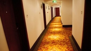 A hotel hallway with a carpeted floor and doors on both sides. - GreenTree Inn Smart Selection Hotel (Guanyun Wenzhou Trade City Jiulong Square Branch) (Lianyungang)