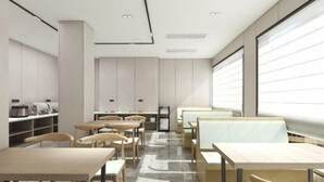 A modern restaurant interior with wooden tables and chairs, a central counter, and a large window. - GreenTree Inn Smart Selection Hotel (Guanyun Wenzhou Trade City Jiulong Square Branch) (Lianyungang)