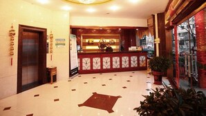 A hotel lobby with a reception desk, a chandelier, and a large potted plant. - GreenTree Inn Huaian Chuzhou Avenue Zhou Enlai Memorial Hall Hotel (Huai'an)