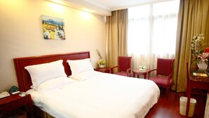 A hotel room with a large bed, two bedside tables, a desk with a chair, a small table with a chair, and a window with curtains. - GreenTree Inn Huaian Chuzhou Avenue Zhou Enlai Memorial Hall Hotel (Huai'an)