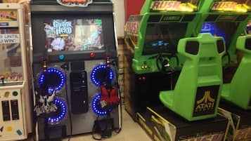 A row of arcade machines, including Guitar Hero and Rush, in a gaming area.
