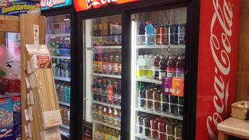 Máquina expendedora llena de bebidas y aperitivos, incluyendo un refrigerador de Coca-Cola.