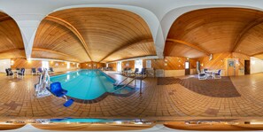 A panoramic view of a swimming pool area with a wooden ceiling, poolside seating, and a checkered floor pattern.