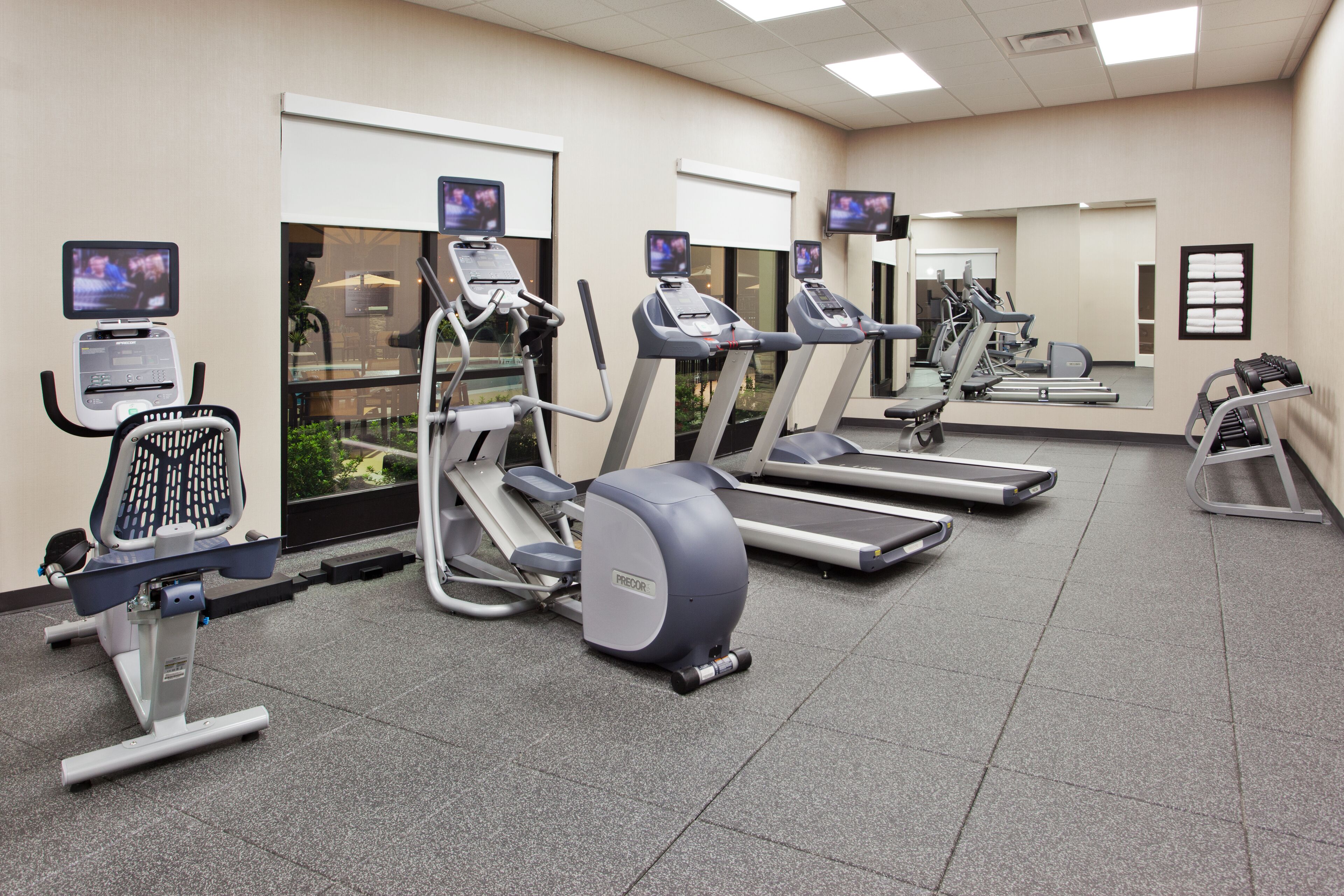 A fitness center with treadmills, elliptical machines, and stationary bikes.