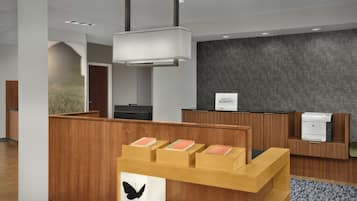 A modern reception desk with a wooden finish, a black butterfly decoration, and a sign for 'MARRIOTT BONVOY'.