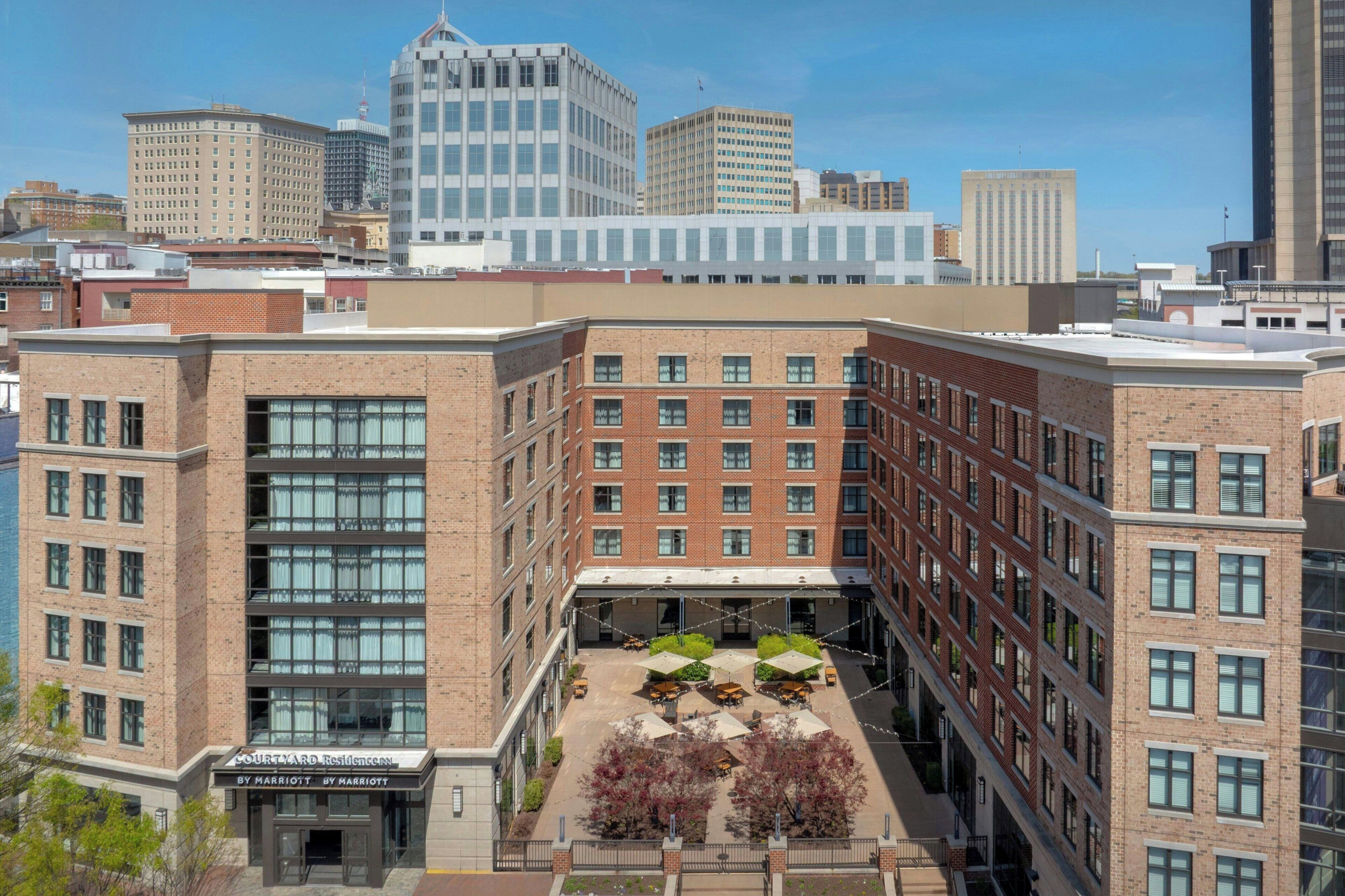 A hotel with a courtyard, brick facade, and multiple floors.