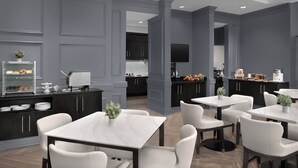A modern restaurant with a grey and black color scheme, marble tables, and white chairs. - Residence Inn by Marriott Richmond Downtown (Richmond)