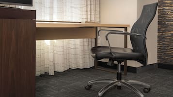Un espacio de oficina moderno con un escritorio, una silla y un televisor.