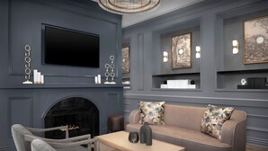 A modern living room with a fireplace, a sofa, a TV, and decorative wall art. - Residence Inn by Marriott Richmond Downtown (Richmond)