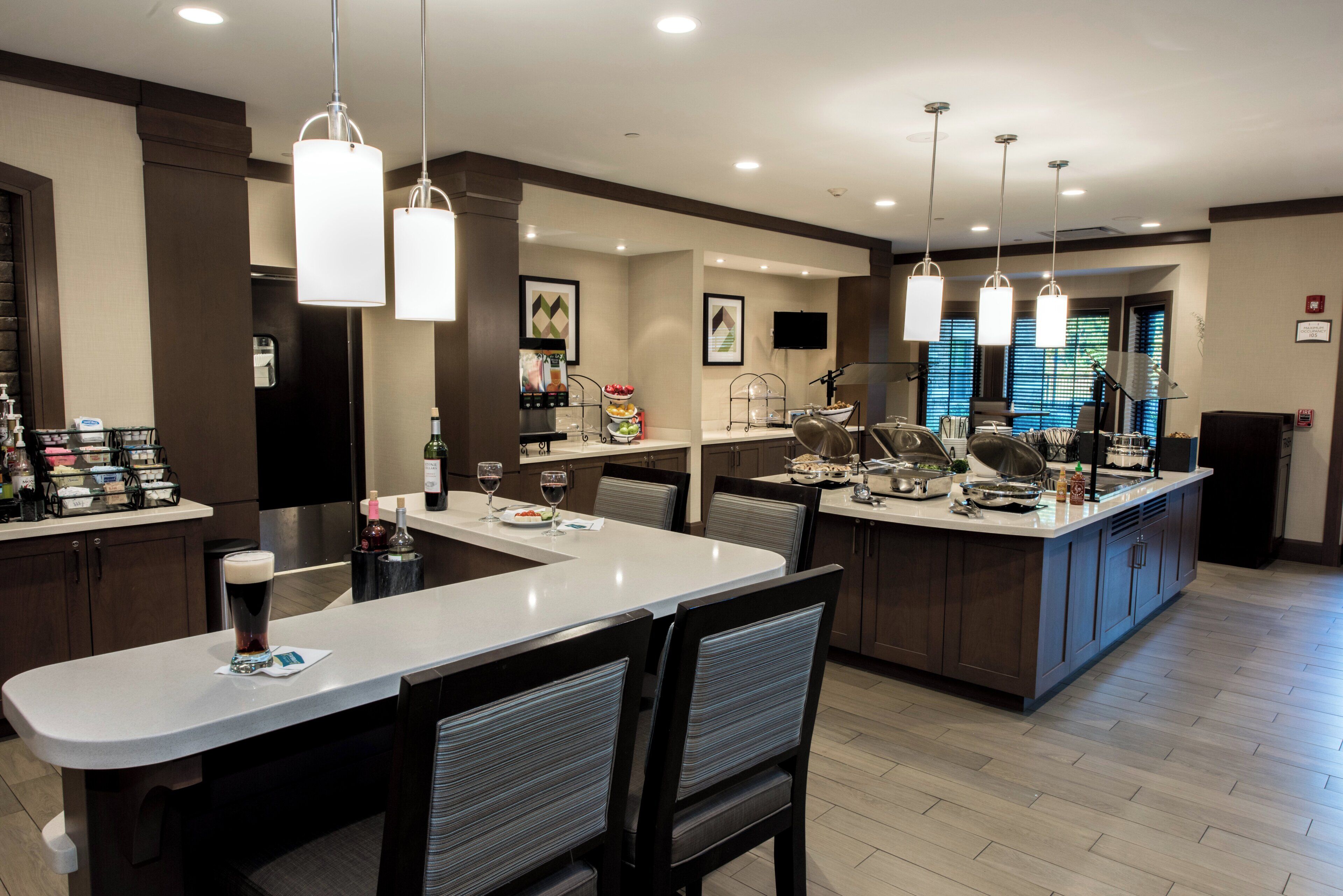A modern kitchen with a central island, bar area, and seating.