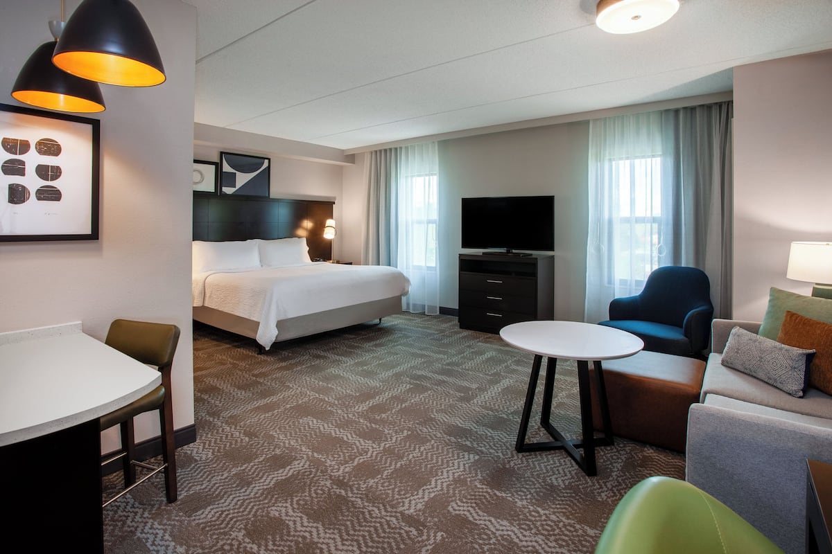 Une chambre d’hôtel équipée d’un lit, d’une télévision, d’un bureau et d’un coin salon.