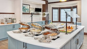 Een buffetopstelling met diverse etenswaren en bestek.