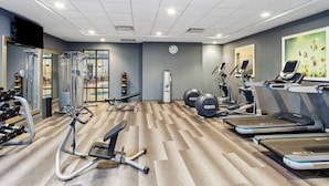 Een moderne sportschool met loopbanden, elliptische machines en gewichten.