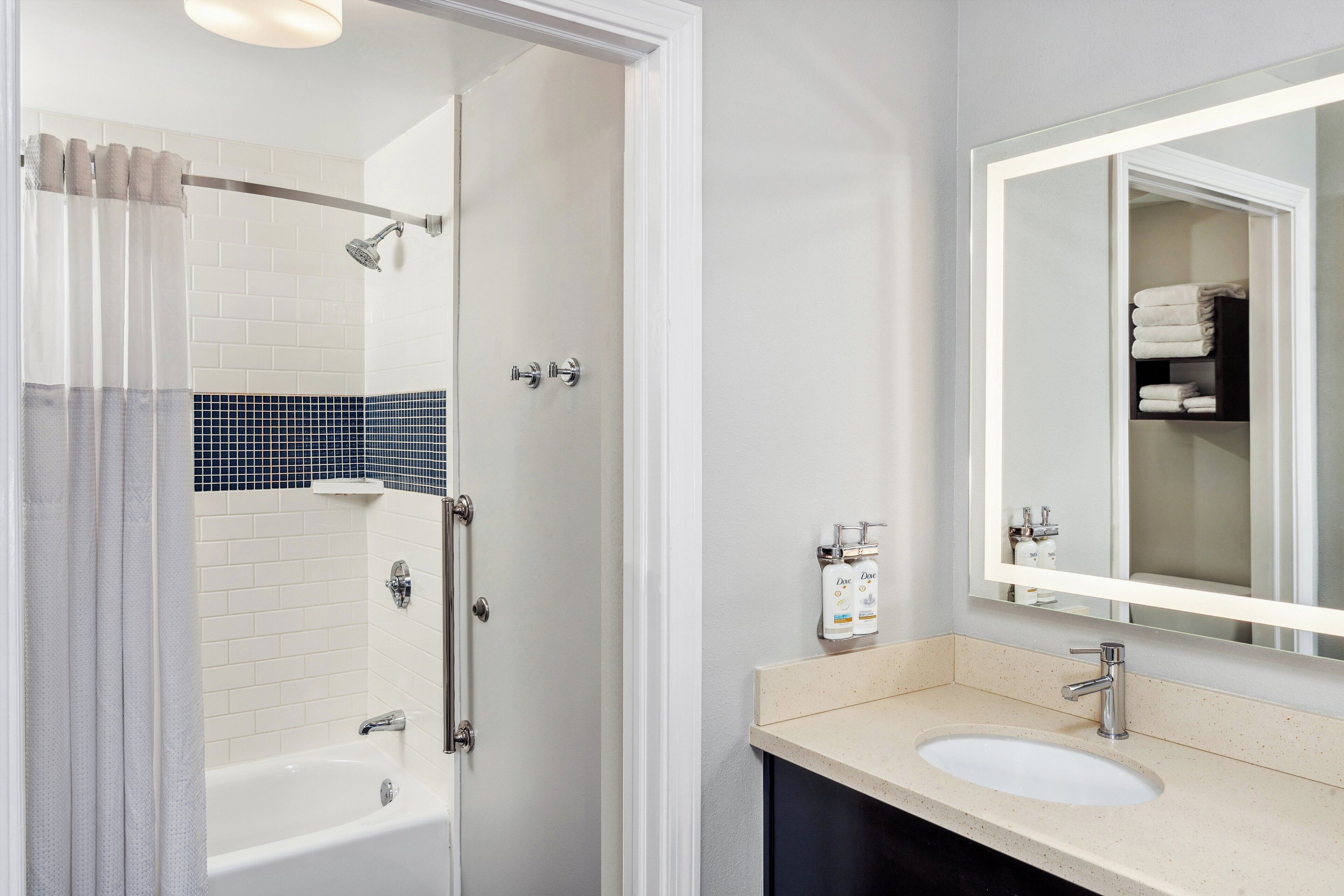 A bathroom with a bathtub, shower, and sink.