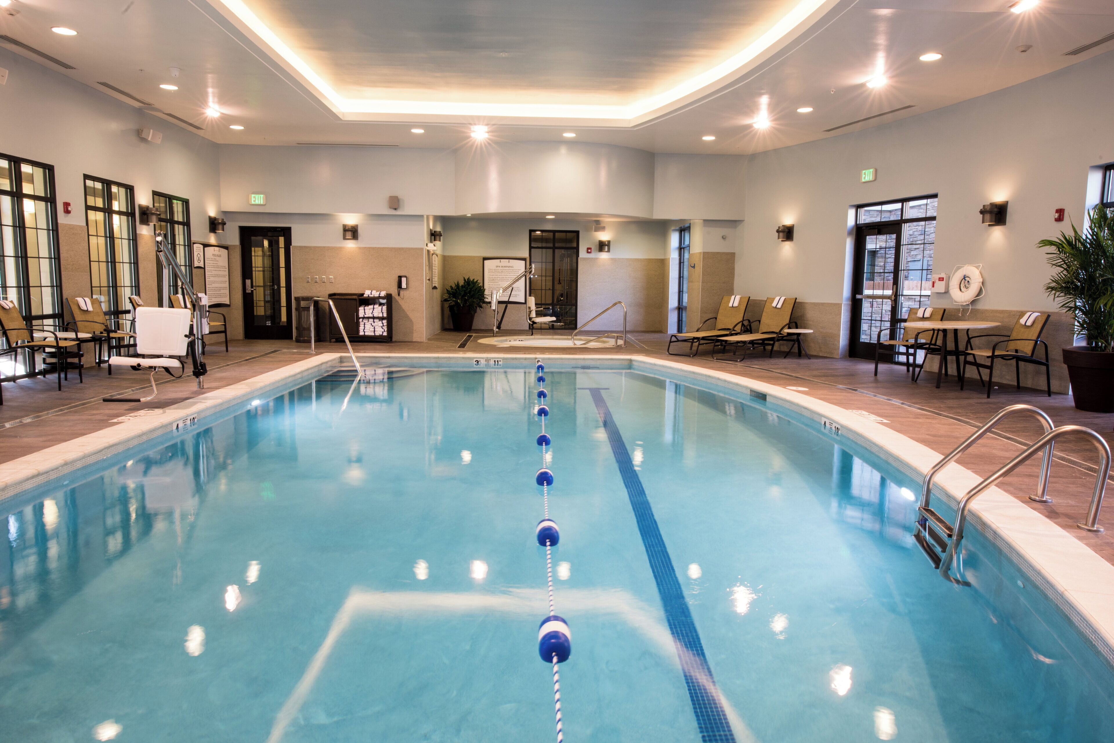 Una piscina techada, sillones reclinables de piscina