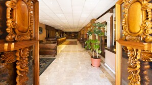 Un amplio pasillo con marcos de madera decorados y una planta en maceta.