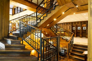 Una escalera de madera con barandillas de metal negro y piso de madera.