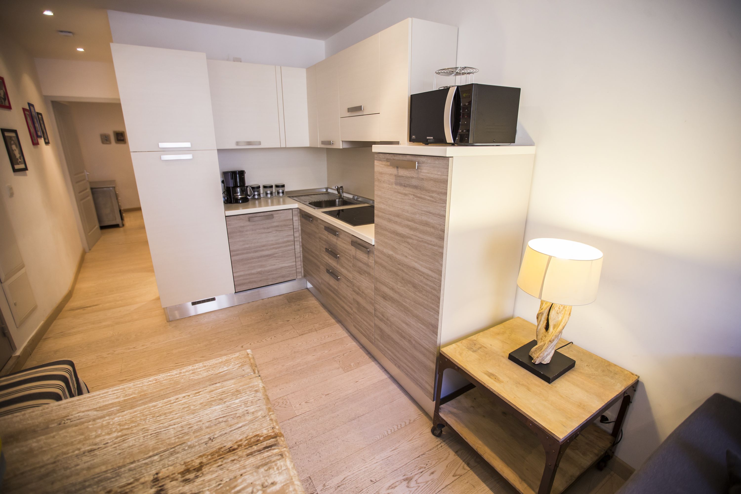 Eine moderne Küche mit weißen Schränken, einer Holz Arbeitsplatte und einer eingebauten Mikrowelle.