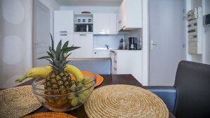 A modern kitchen with white cabinets, a microwave, and a coffee maker. - Residence Bouttau (Cannes)