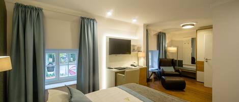 Una habitación de hotel con cama, escritorio, silla y televisor.