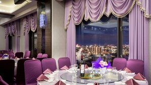 A dining area with round tables, purple chairs, and a city view through large windows. - Royal Chiayi Hotel (Chiayi City)