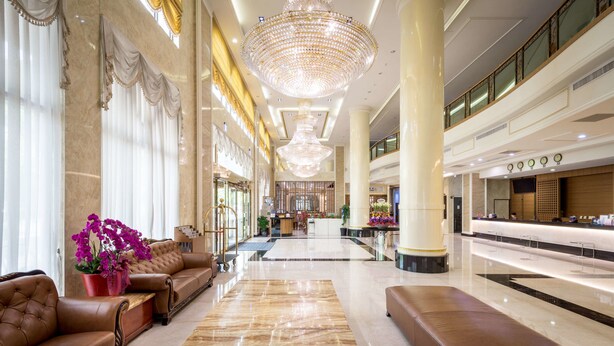 A spacious lobby with a grand chandelier, leather sofas, and a marble floor. - Royal Chiayi Hotel (Chiayi City)