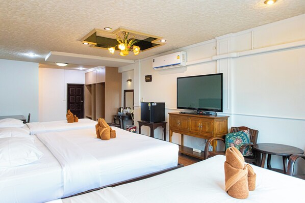 Une chambre d’hôtel avec deux lits, une télévision, un bureau et une chaise.
