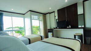 A hotel room with two beds, a television, a small kitchenette, and a balcony with a view of greenery. - The Villa Chiangrai (Chiang Rai)