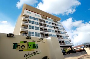 Un hotel de varios pisos con balcones y un cielo despejado.