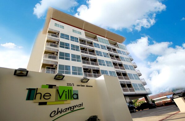 A multi-story hotel with balconies and a clear sky.