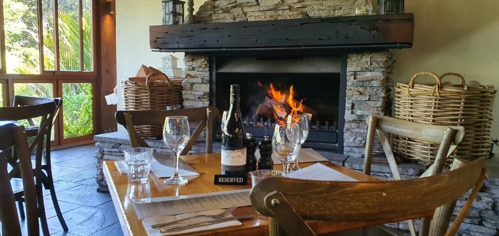A dining area with a fireplace, table set with glasses and cutlery, and a 'RESERVED' sign on the table.