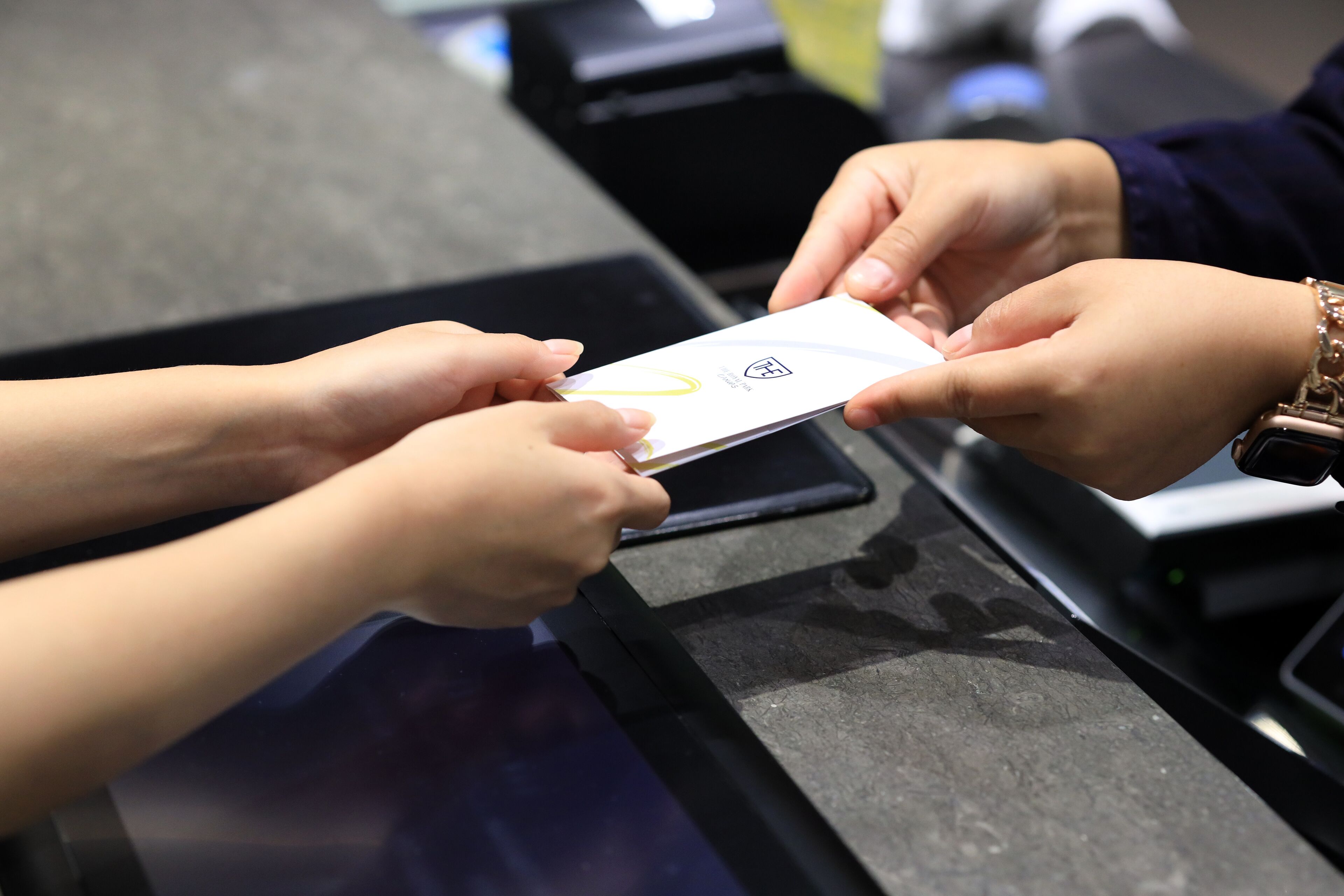 A person handing over a card to another person at a counter.