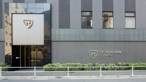 A modern building with a prominent logo and signage for "The Royal Park Canvas Nagoya".