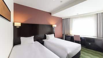 Ein Hotelzimmer mit zwei Betten, einem Schreibtisch und einem Stuhl.