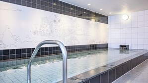 A swimming pool with a tiled floor and a large wall mural.