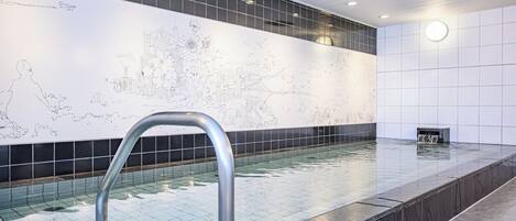A swimming pool with a tiled floor and a large wall mural.