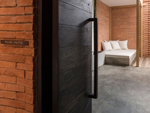 Ein Hotelzimmer mit Backsteinwand, einem Bett mit Kissen und einem Schild, das eine Pool-Suite kennzeichnet.